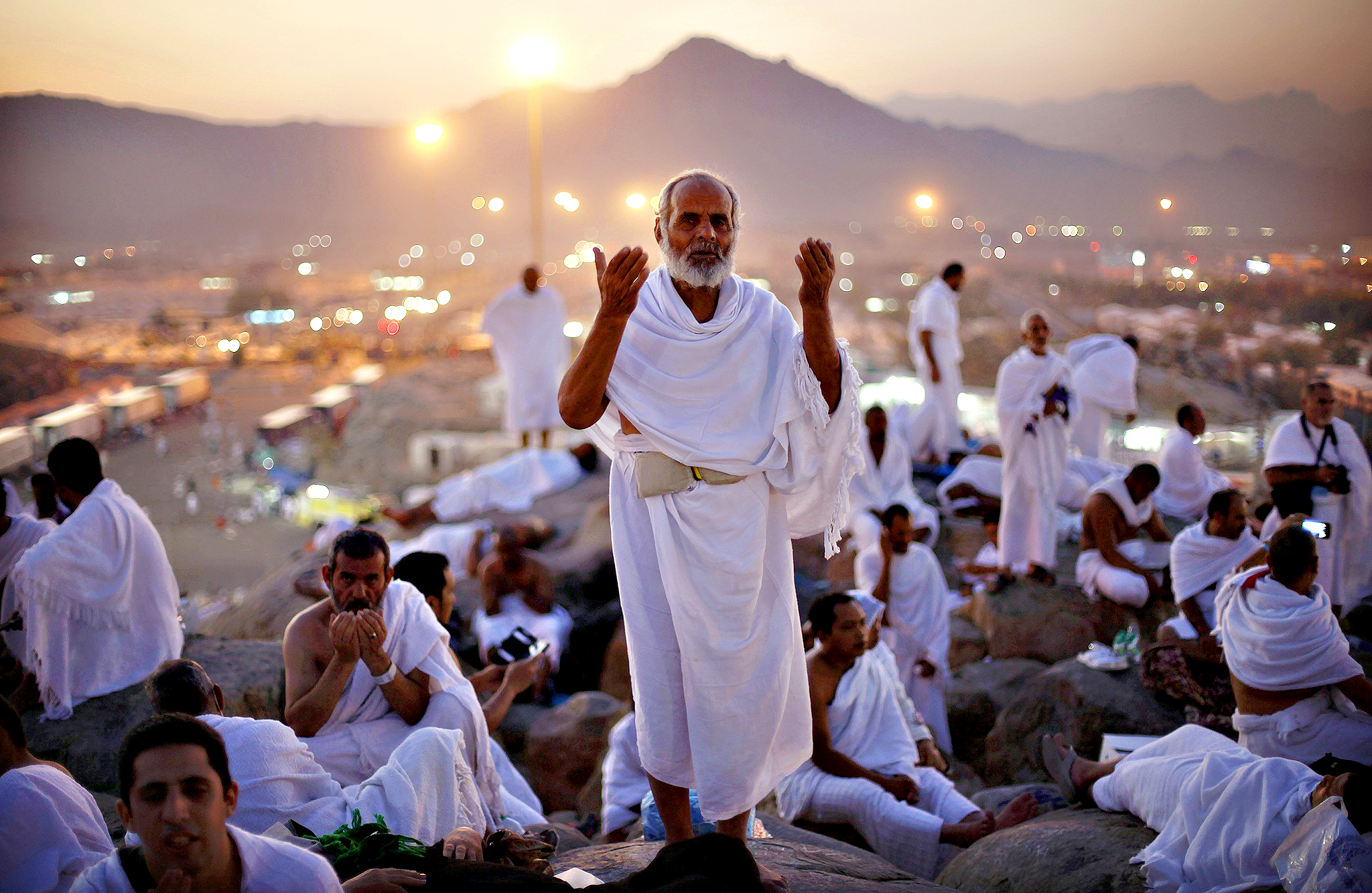 A Muslim pilgrim prays atop Mount Mercy on the plains of Arafat